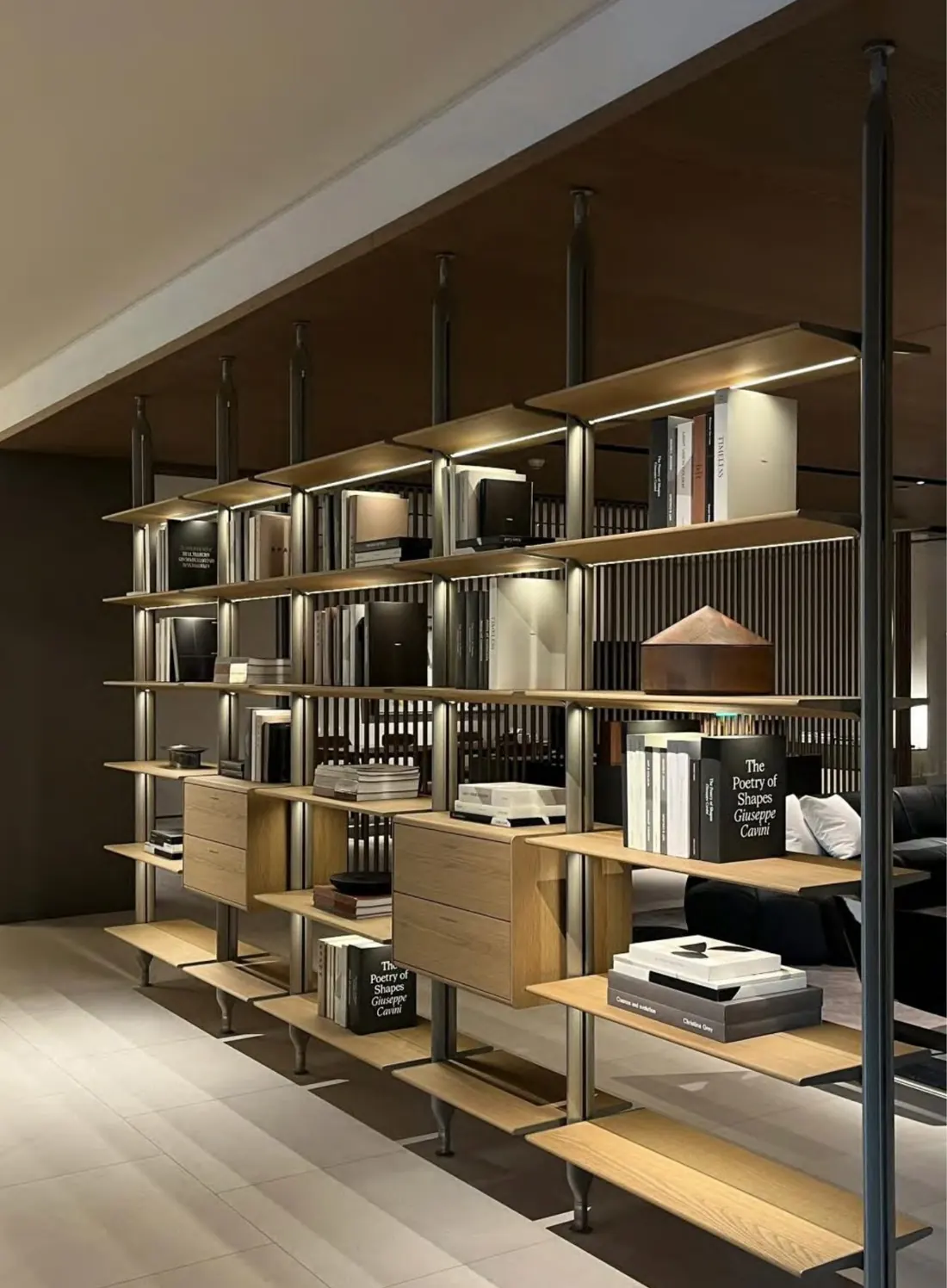Open shelving system with bronze profiles and integrated lighting